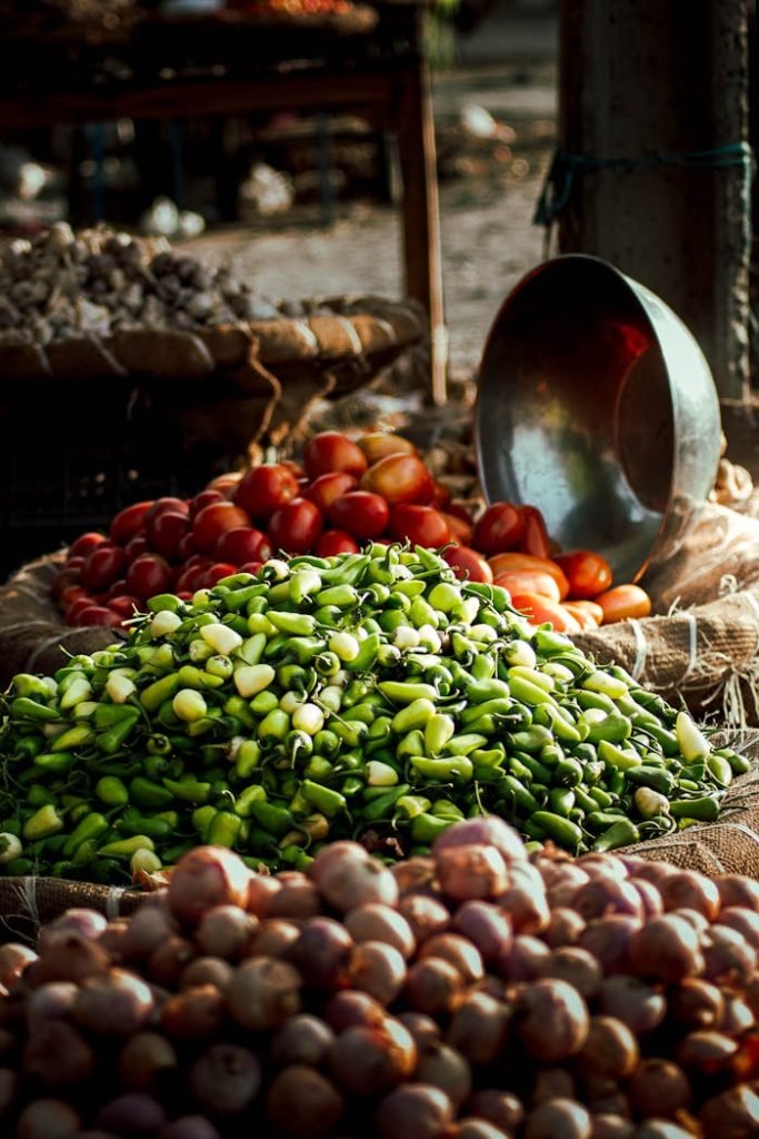 fresh-vegetables-in-baskets-at-market-11925574 Colorful assortment of fresh vegetables at an outdoor market stall, showcasing tomatoes, peppers, and other produce.
